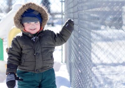 2016 Tenderfoot Child in the snow with a big hooded coat and pink cheeks.