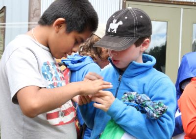 ASC Community Kids Summer Program are busy looking at something in their hands.