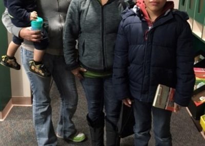 Two ladies, a young boy, and a toddler at the Center for Adult and Family Education at the Library.