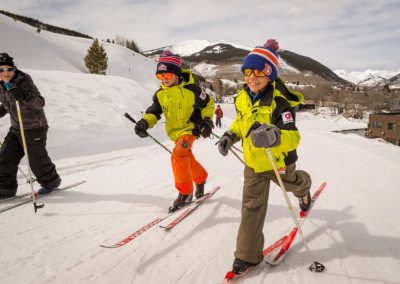 Three young Skiers Nordic Skiing in Crested Butte with big grins on their faces. Photo by Xavier Fane.