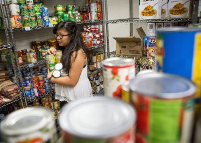 A volunteer stocks Food Pantry shelves for the Gunnison Country Food Pantry Endowment.