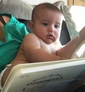 Baby Koa Villanueva reads a story book in diapers.