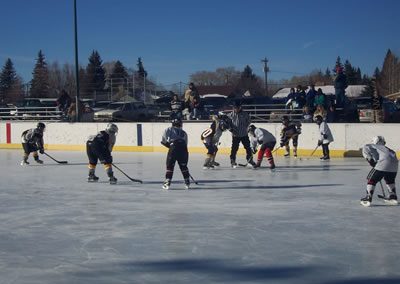 Young hockey players playing a game outside in the winter.