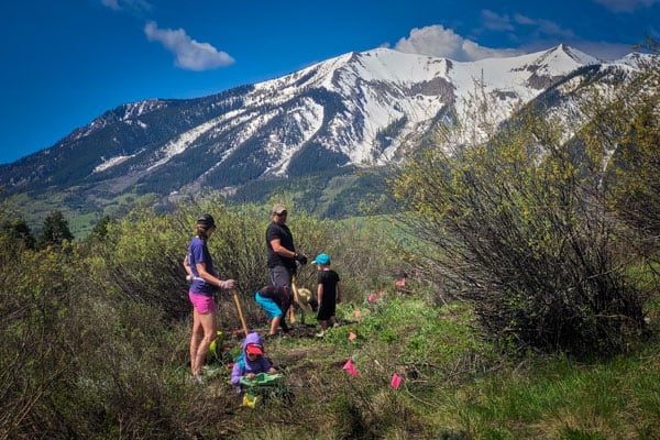 CBMBA Trail Work Day three kids and two adults helping build a new trail with Mt. Whetstone in the background