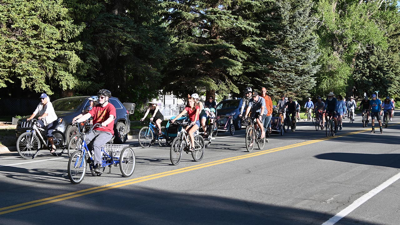 group of bicyclists cruising through downtown Gunnison for a Music Cruise