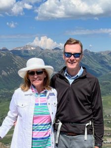 Lenni and Bill Burke outside on a sunny day with mountains in the background