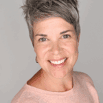 Smiling woman with short hair in a pink sweater